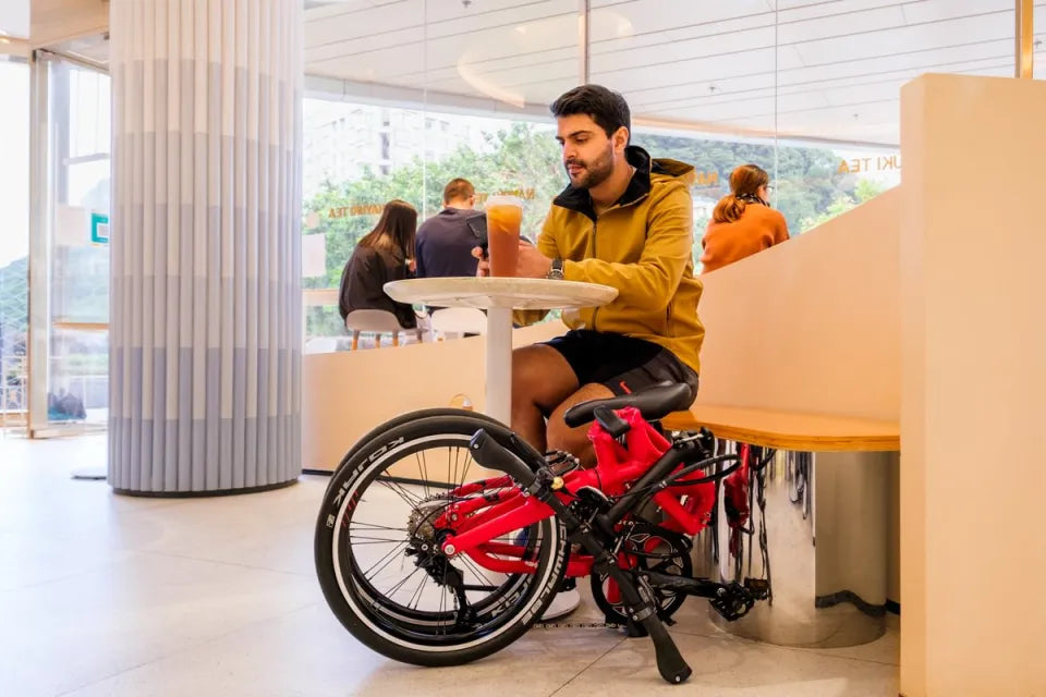 Man seated in cafe with Tern folding bike next to him