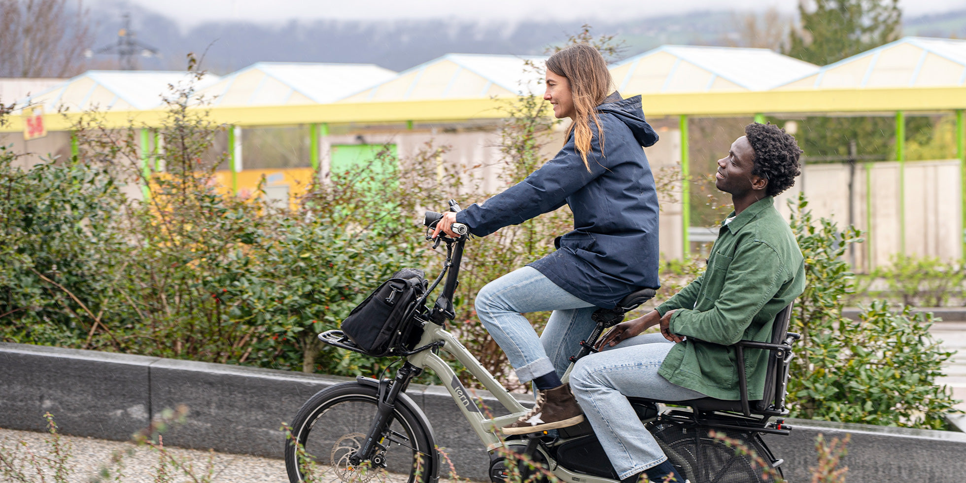 Woman riding Tern HSD cargo e-bike with man sitting on back