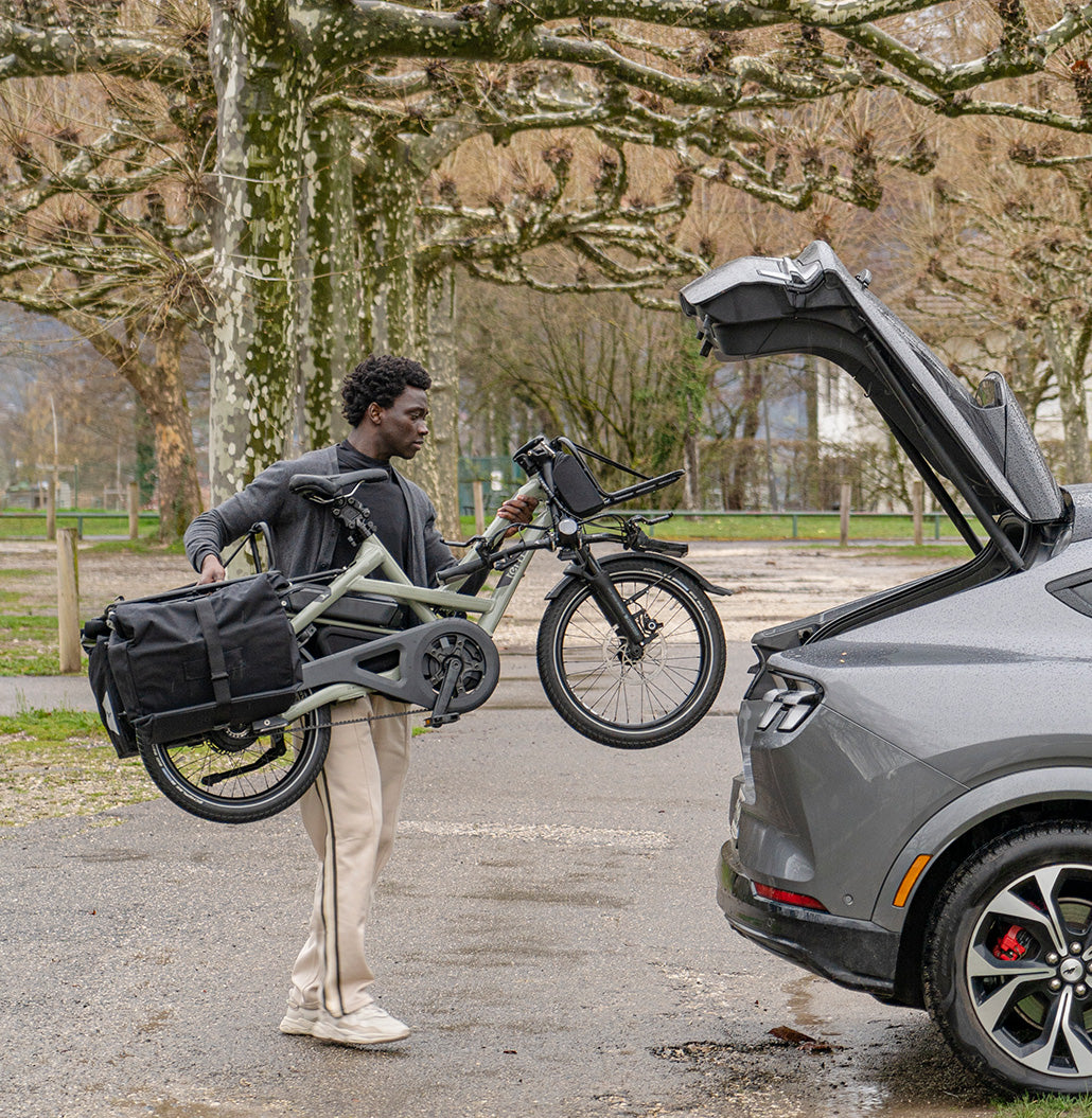 Man loading HSD cargo e-bike into the back of a car
