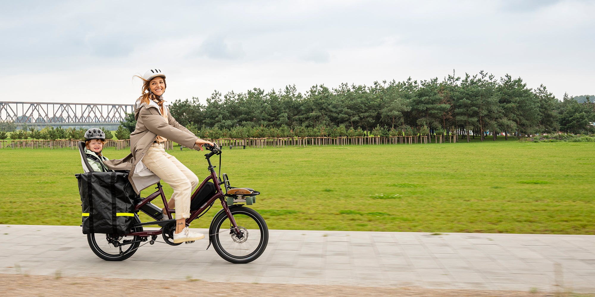 Woman riding Tern Quick Haul e-bike with child on the back