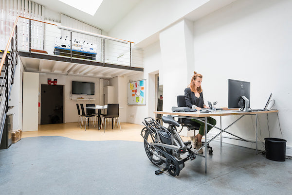 Tern Vektron e-bike folded next to woman's desk