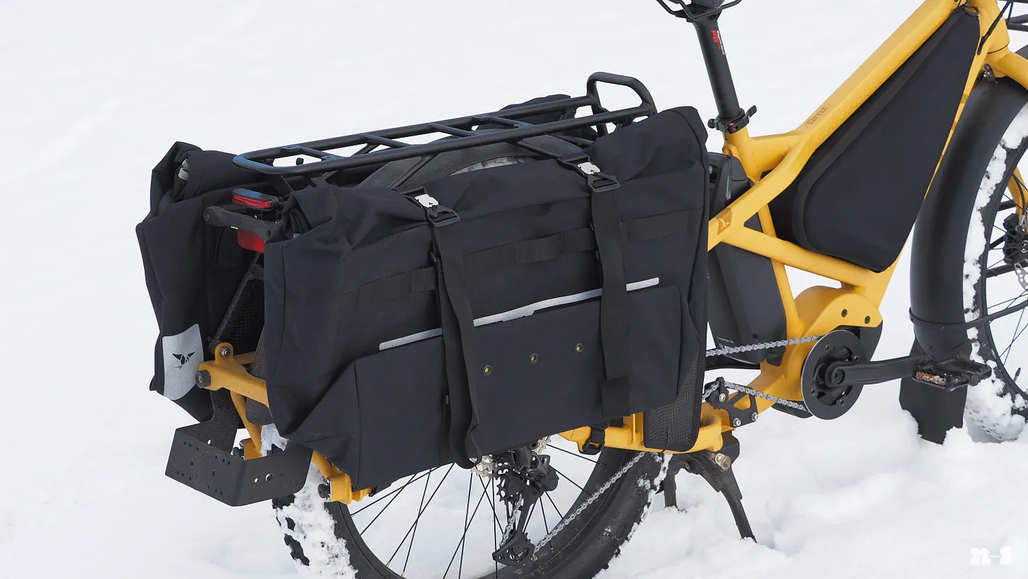 Tern Orox adventure cargo e-bike pictured in the snow with strong, huge rear rack and oversized panniers. Image James Huang N-1