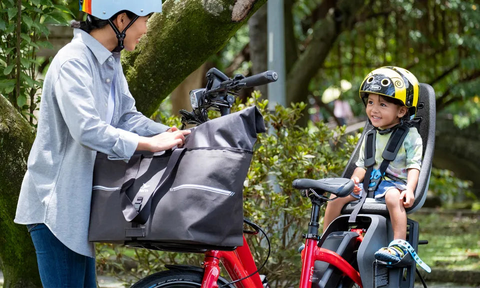 Woman with child seated on the back of a Tern NBD e-bike